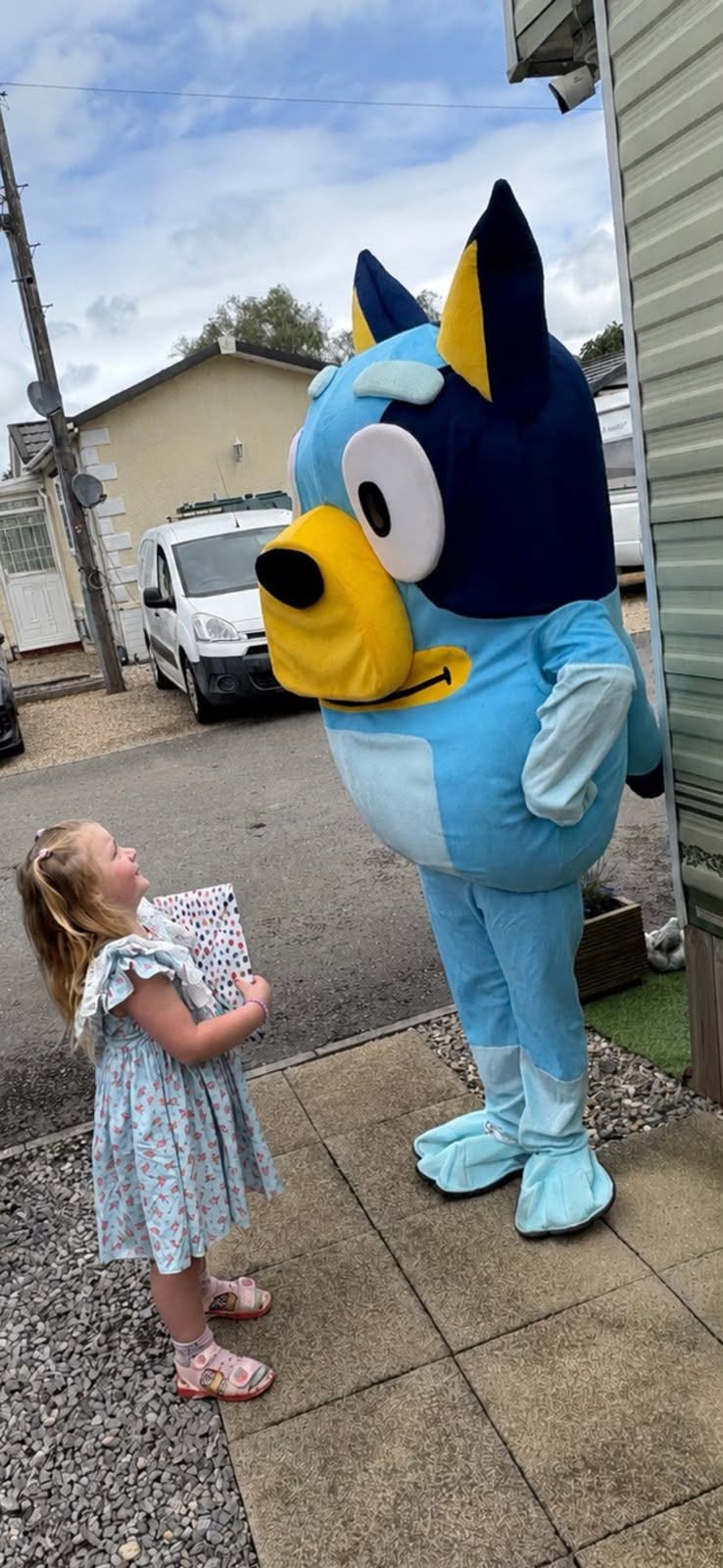 Child meeting a blue cat character costume at home