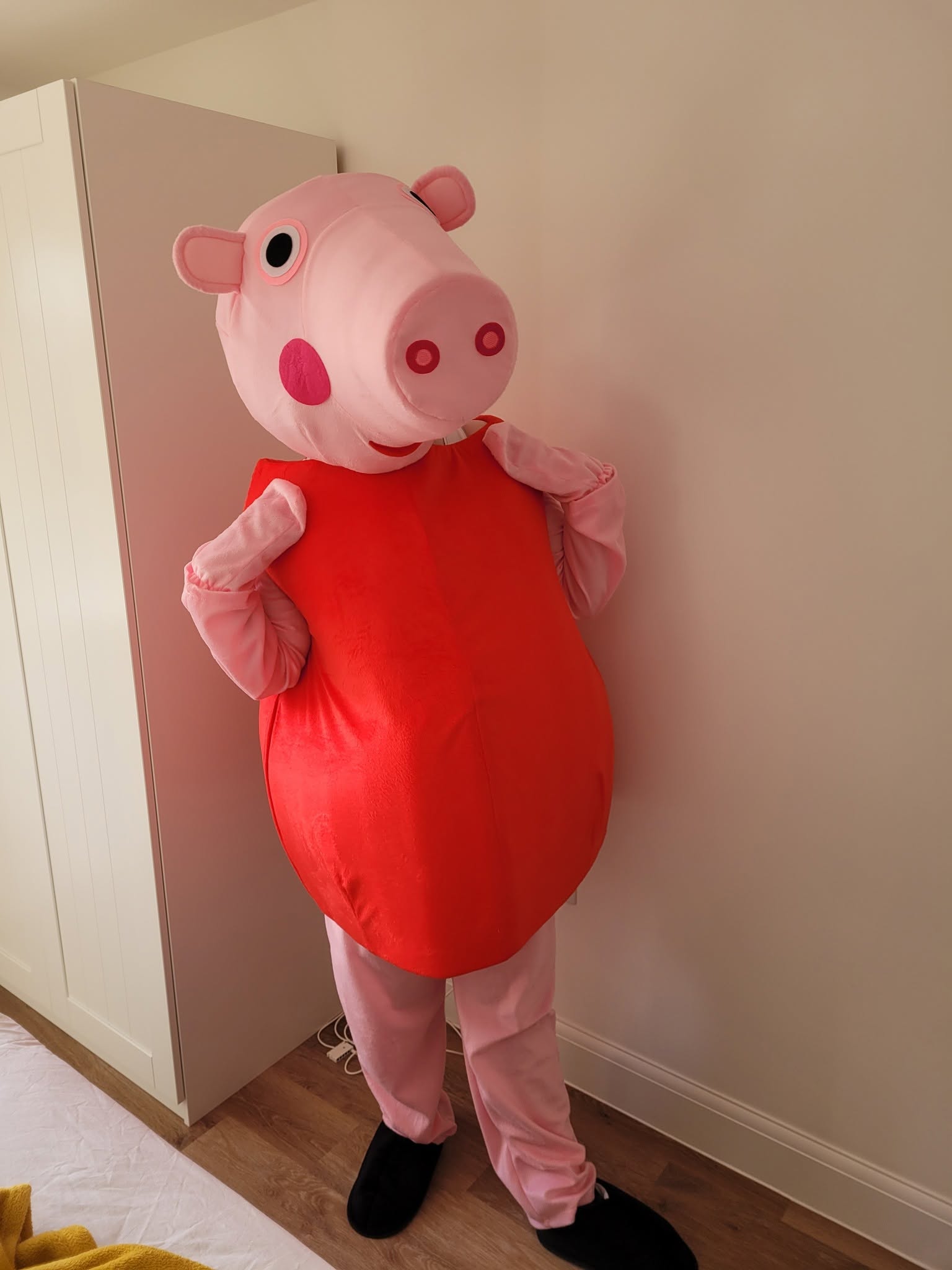 Pink pig character mascot in a red outfit