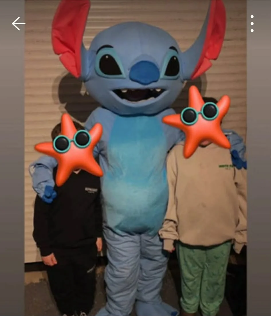 Child posing with a costumed Paw Patrol character outdoors