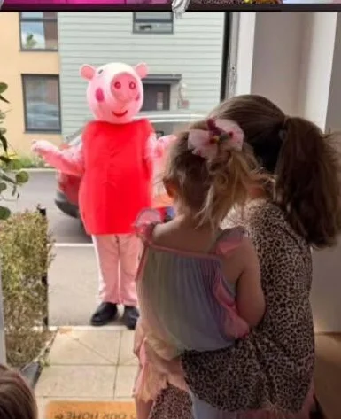 Child posing with an oversized Chase Paw Patrol character